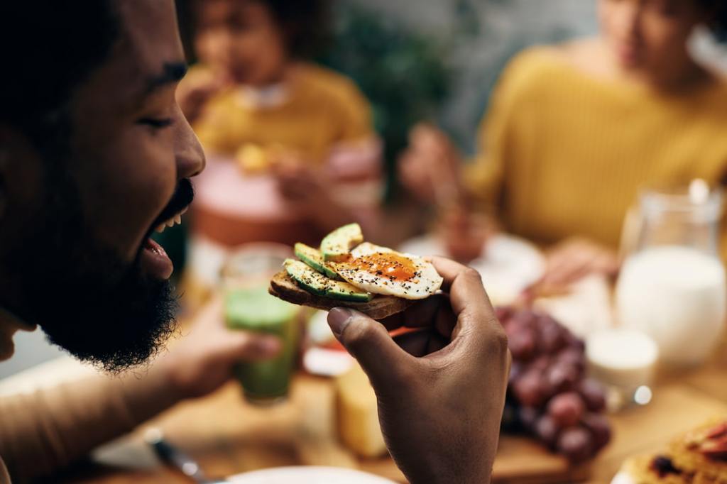 Man eating egg and avocado toast