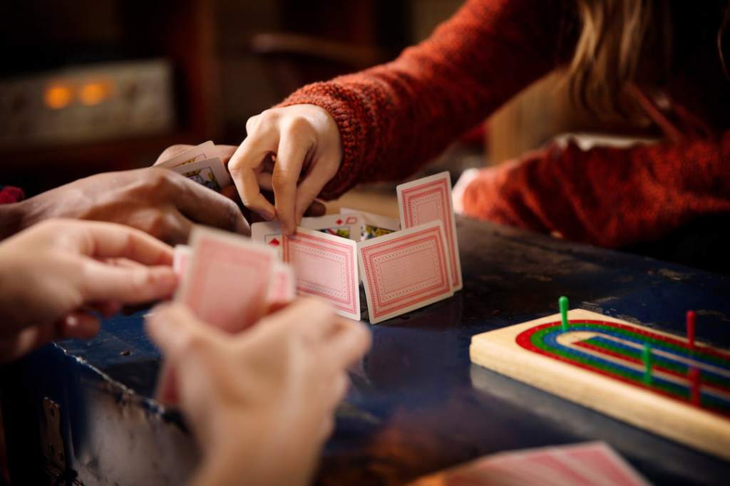 Woman in red sweater playing pinochle with another person at the table