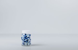 blue and white pills in clear bottle