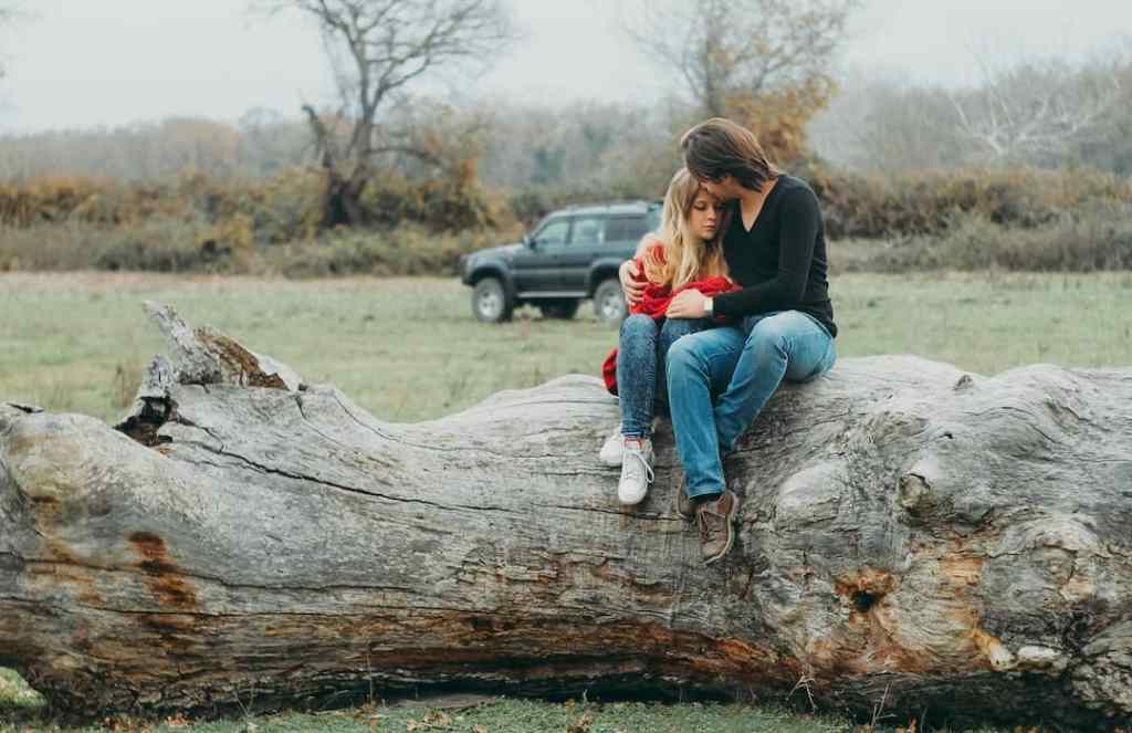 Couple sitting on tree close together