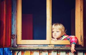 child looking out of multicolored window