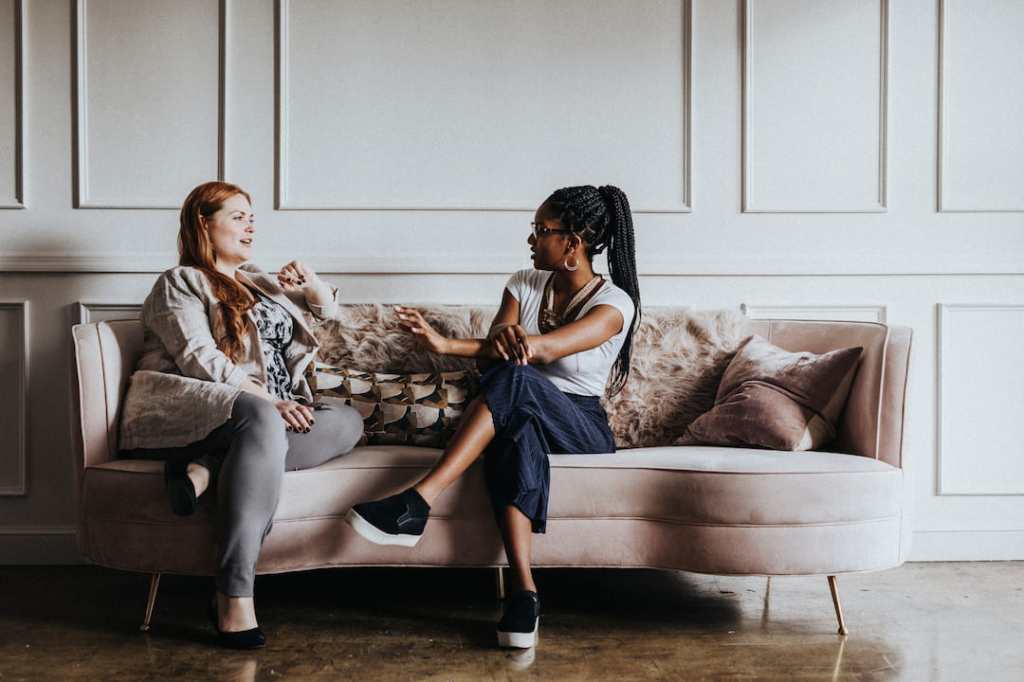 Two women chatting on a couch