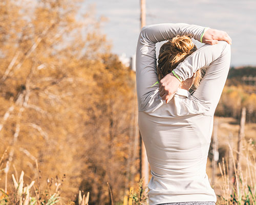 woman stretching in field