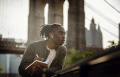 Man with earphone in journaling in front of a bridge