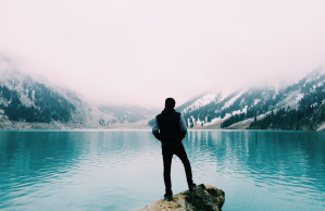 Lonely man observes isolated glacial lake