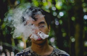 Man exhales smoke outside