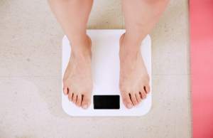 Person standing on white digital scale.