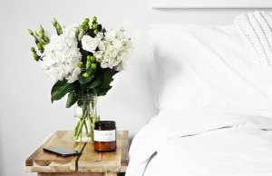 white bed with flowers and candle
