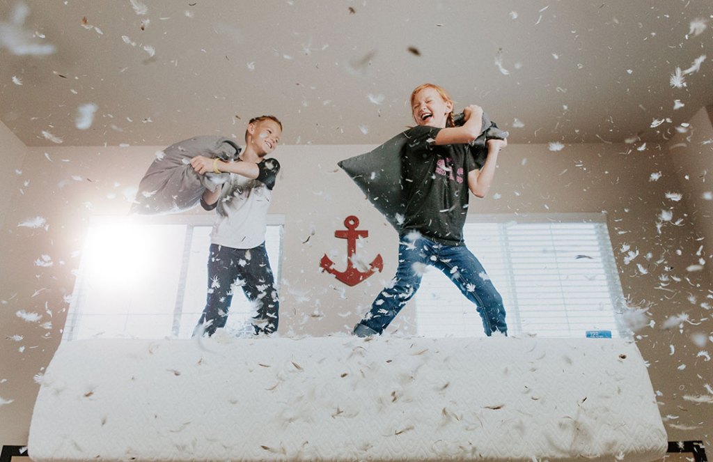 two children pillow fighting