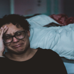 woman-crying-next-to-bedside
