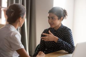 Two people talking to each other at a table