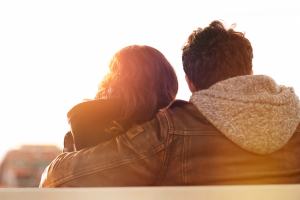 Couple holding each other on a bench