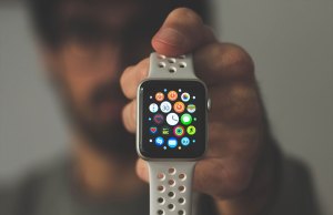 blurry man holding apple watch with holey band