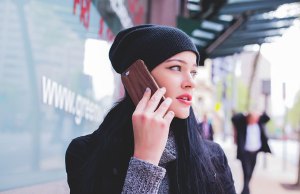 women in black hat with smart phone