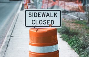 sidewalk closed sign on orange cone