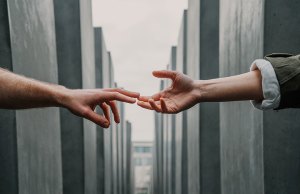 two hands touching in front of concrete structure