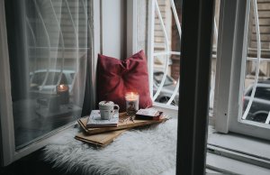 red pillow with books and candle