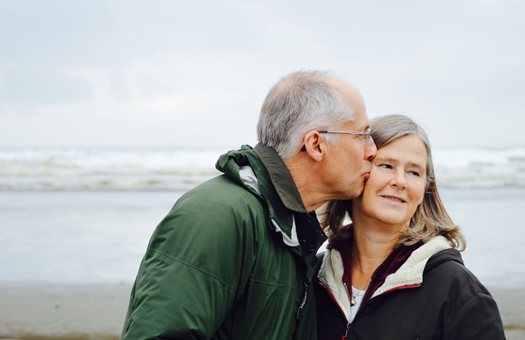 older couple kissing at beach