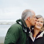 older couple kissing at beach