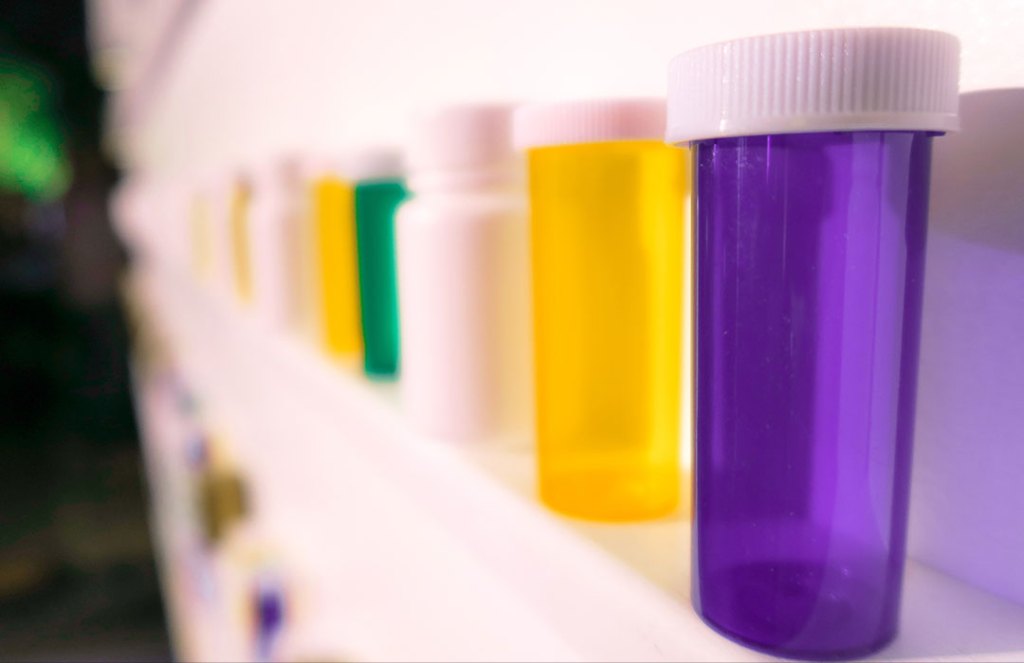purple, yellow white and green pill bottles