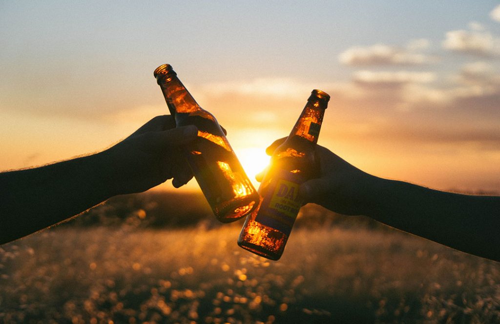 two beer bottles by sunset