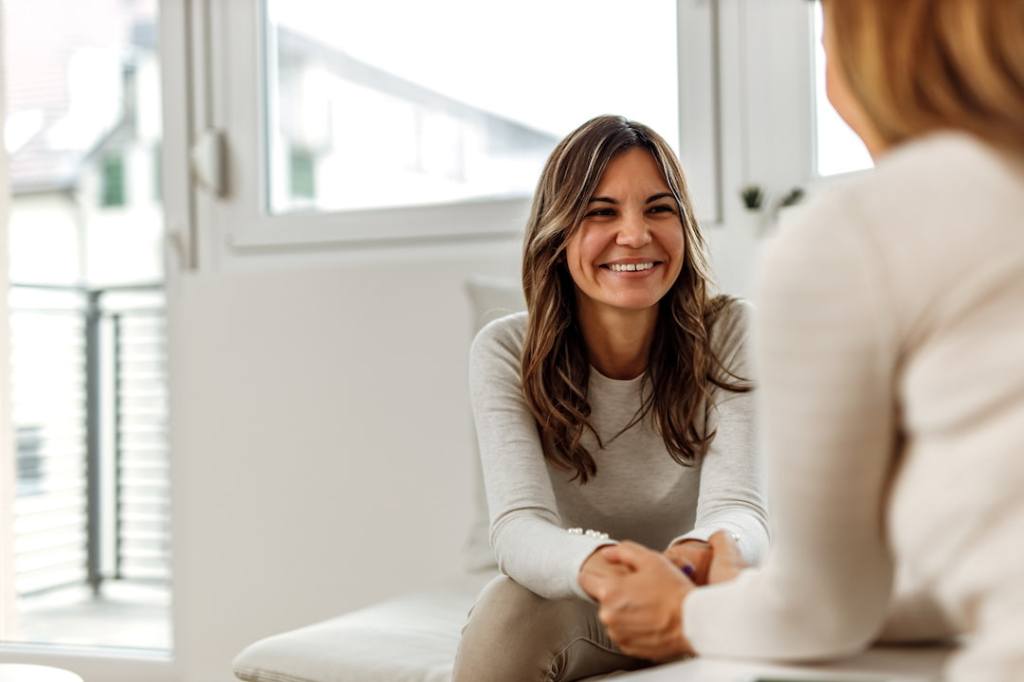 Senior woman sitting on chair- looking away- smiling stock photo