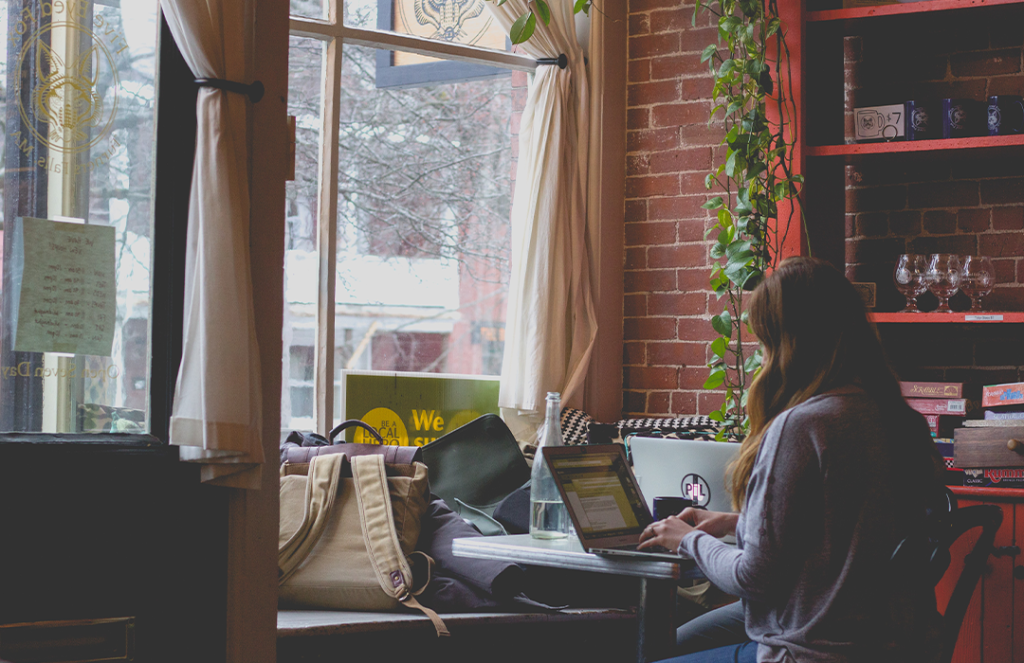 woman sitting at table using laptop