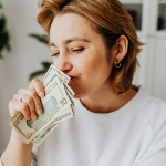 woman wearing white sweater holding money
