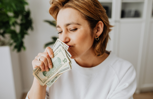 woman wearing white sweater holding money