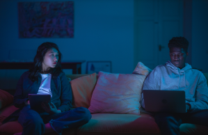 Couple sits on couch in dark