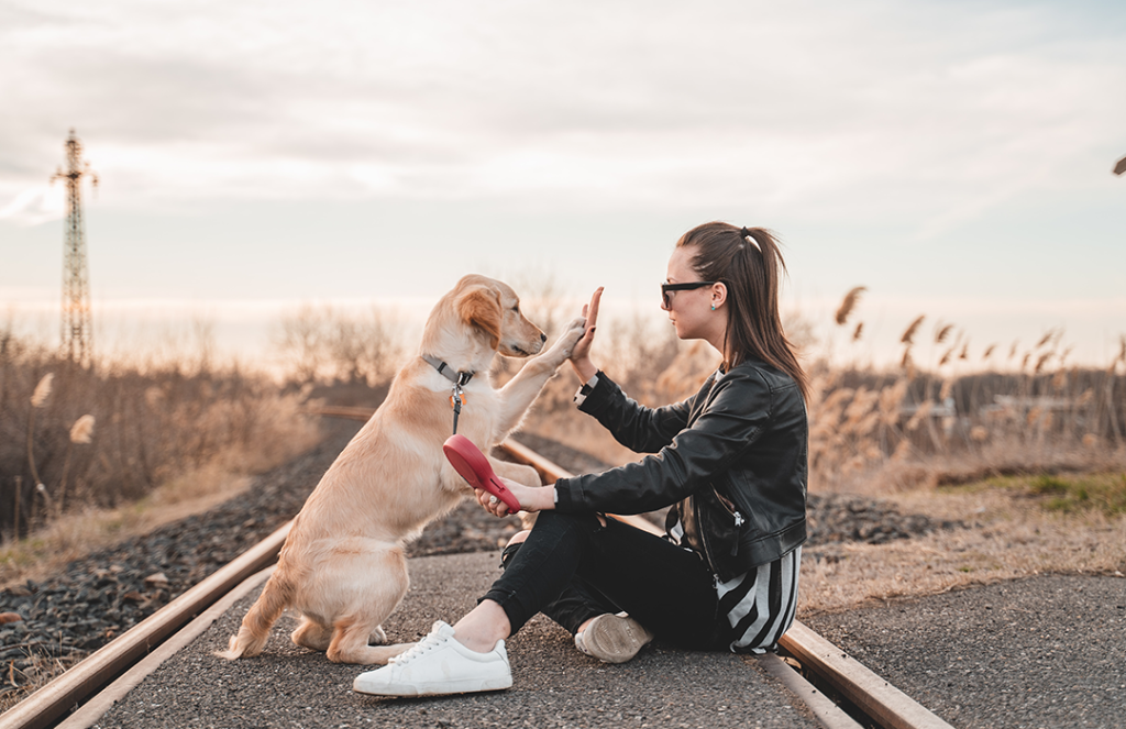 woman sitting outside playing with dog