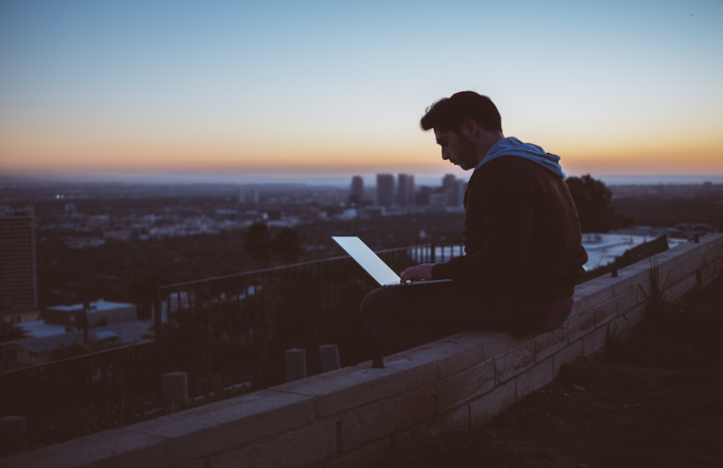 man-sitting-on-concrete-brick-wall