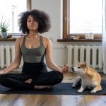 woman-doing-yoga-beside-dog