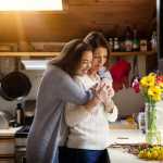 Daughter hugging her mother in the kitchen