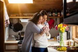 Daughter hugging her mother in the kitchen