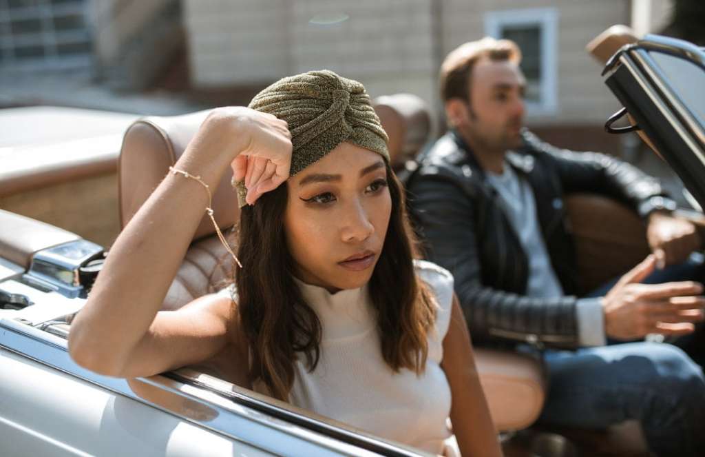 Sad woman in turban sits in passenger side of convertible car