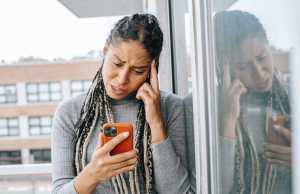 tired-black-woman-browsing-mobile-phone