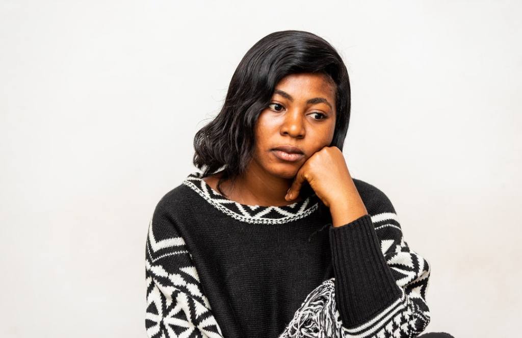 Melancholy woman is thoughtful in chunky black and white sweater