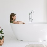 Woman sits in bathtub fully clothed