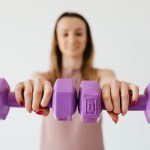 purple-dumbbells-in-hands-of-positive-sportswoman