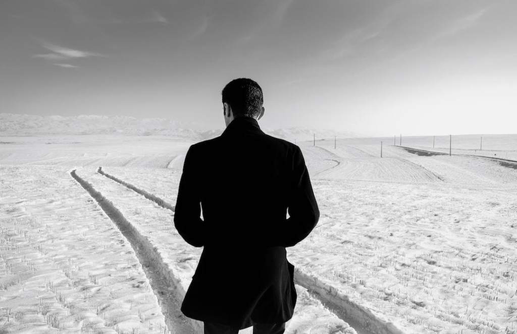 unrecognizable-man-in-snowy-field