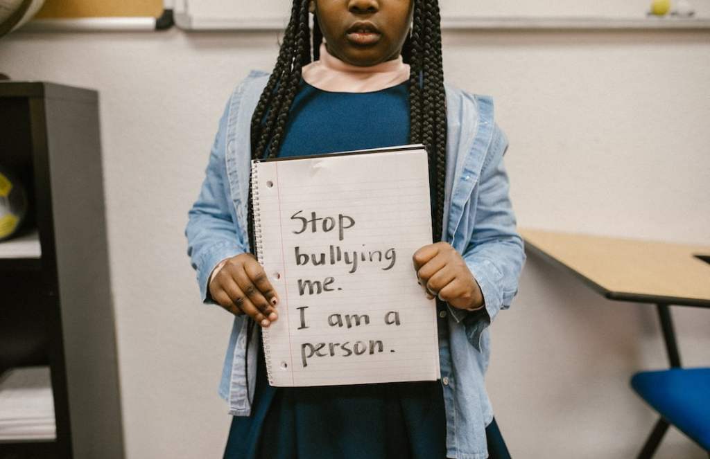 Girl holding notebook that says stop bullying