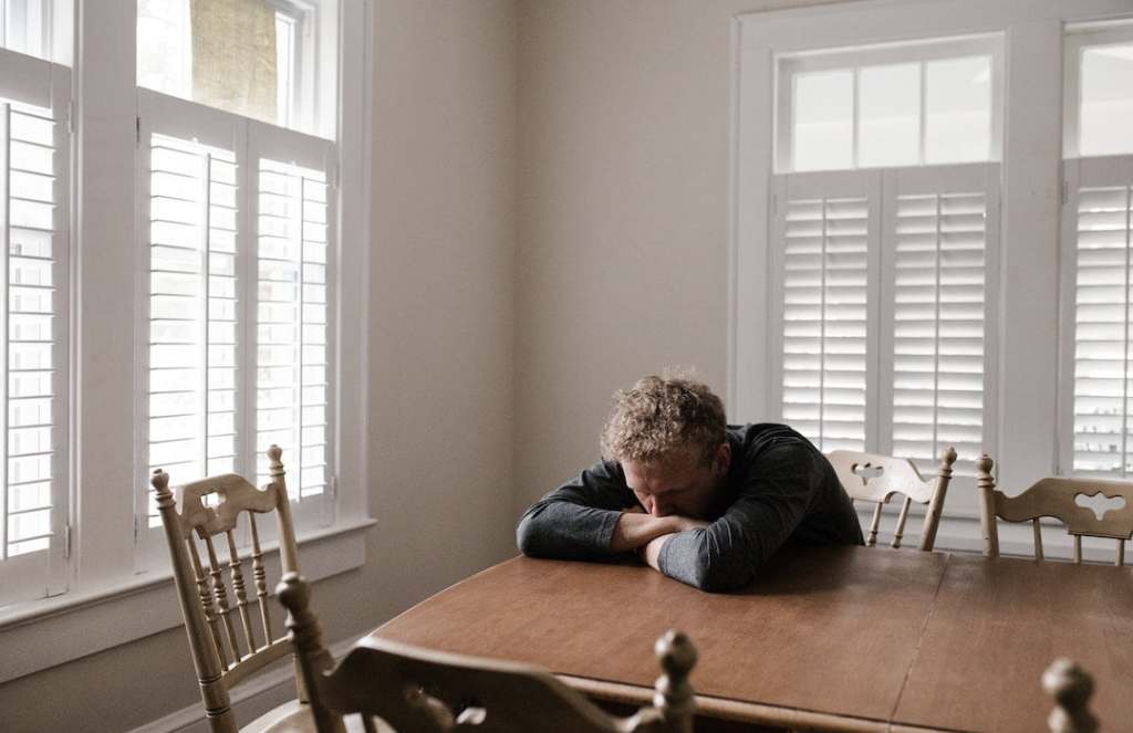Man sitting at a table by windows