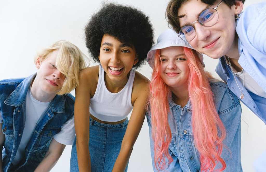 Multiethnic teens hanging out in front of a white background