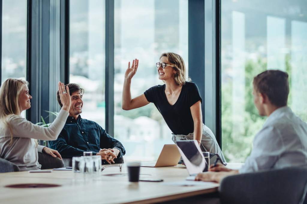 People in conference room high-fiving