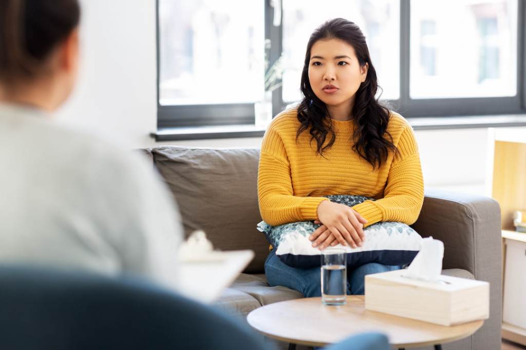 Woman on a couch talking to a therapist