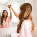 Woman drawing a heart on mirror and smiling