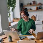 Woman using multiple computers at a desk