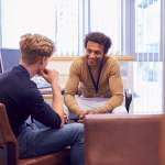 Male college student meeting with counselor during therapy session