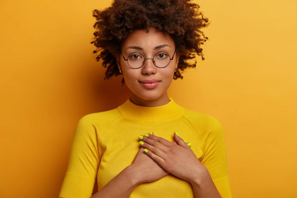 Woman with yellow shirt with hands over her heart
